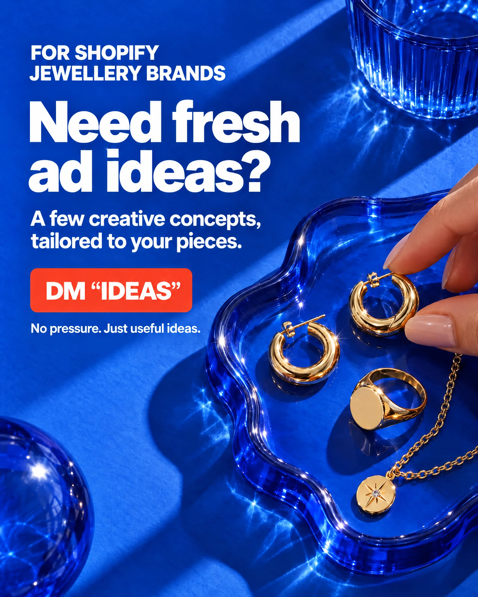 Blue Shopify jewellery ad with gold hoops, rings and a pendant on a glass tray, Need fresh ad ideas? headline and DM IDEAS call to action